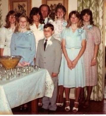 Marty Quirk as a boy in a suit with Clarence and Bonnie Latham and their five daughters